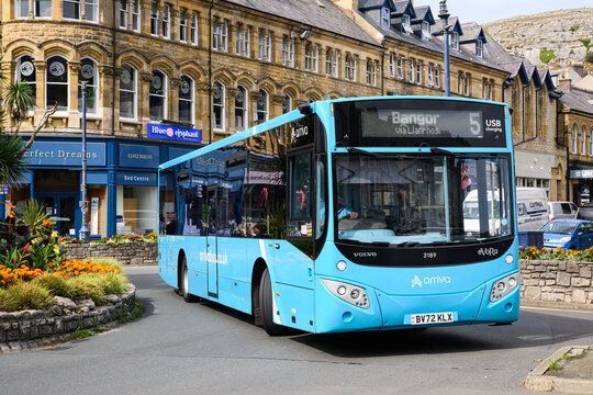 Llandudno, Wales, UK - September 6, 2025; Pale blue Arriva bus turning at roundabout in summer