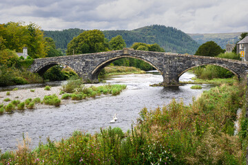 Fototapeta premium Llanrwst Bridge Pont Fawr crossing River Conway in North Wales landscape
