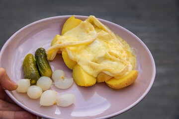 Melted raclette cheese on top of boiled potatoes, the Zurich Christmas Market