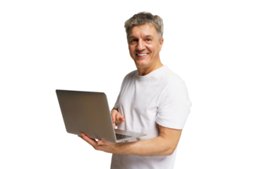 Older man uses laptop and smiles in home setting