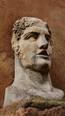 Obraz premium Rome, Italy - 12 January 2025. Carved stone head of a youthful man with curls and a fractured surface, set into the outer wall of Castel Sant’Angelo.