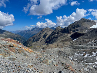 Alpine landscape showing rugged mountains, valley, and blue sky