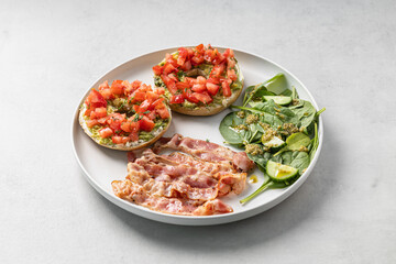 Balanced breakfast with avocado bagels bacon and salad