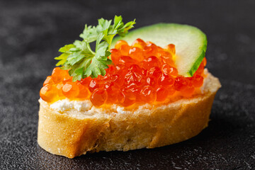 Baguette appetizer with red caviar, cucumber and parsley