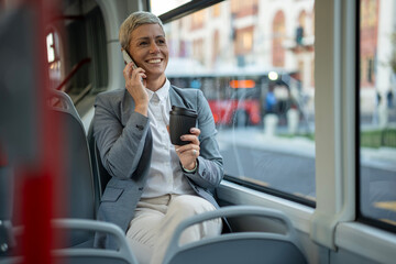 Happy businesswoman communicating on phone while commuting