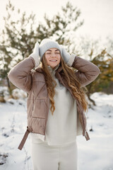 Portrait of a young woman standing in forest at winter day