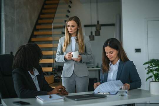 Businesswomen discussing a challenging document with concerned expressions