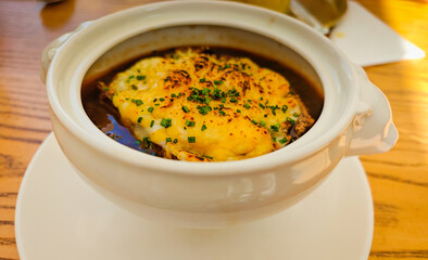 French onion soup with croutons and cheese served in a bowl at a street restaurant in Dubai, UAE. Classic traditional French soup