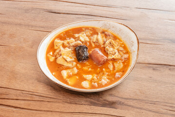 A classic, homemade version of Madrid-style tripe, with tripe cut into strips, chickpeas, and pieces of chorizo, served in a cast-iron casserole dish
