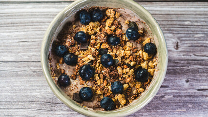 Healthy yogurt bowl with whey protein, crunchy granola, chocolate chunks, and fresh blueberries. Nutritious, protein-packed breakfast or snack for fitness and wellness lifestyles.