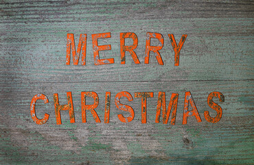 Buchstaben mit der Schrift Merry Christmas mit Glitzer auf einem alten Holzuntergrund