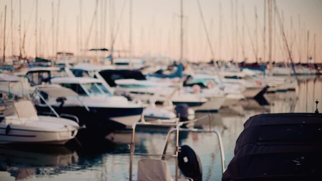 View of a busy marina with many boats and masts, creating a dreamy bokeh effect over calm harbor water