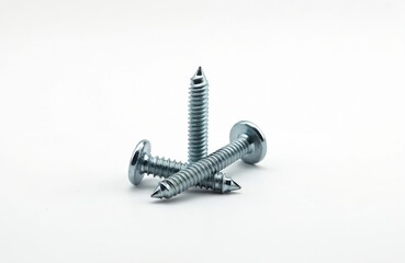 Metal screws with threaded shafts and round heads lie on a white background. Fasteners are used for construction and repair work. Tools for building and assembly.