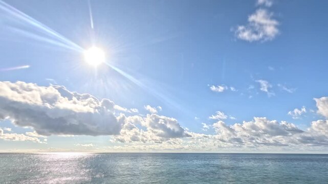 Ocean, clouds, sky, time-lapse of beautiful sparkling water and white fluffy clouds in a serene blue sky over the horizon, natural beauty