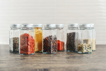Assorted spices in glass jars with metal lids