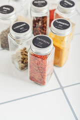 Assorted spices in glass jars with metal lids