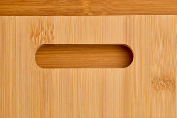 Close-up of bamboo cutting board with oval cutout handle