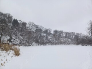 Wide valley riverbed covered in deep winter snow.