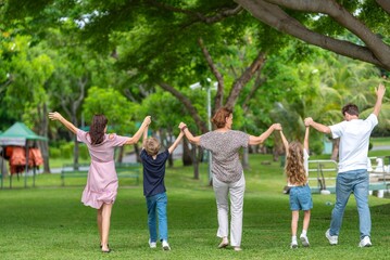 Happiness family outdoor joyful enjoying nature bonding in nature intergenerational happiness. Multigenerational family walking in park outdoor fun lifestyle relaxing smiling walking connection