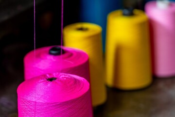 Colorful silk threads closeup vibrant textile yarn cones embroidery Thread spinning yarn production process textile and fiber industry equipment manufacturing. Macro view of vibrant silk cones