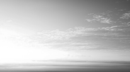 Obraz premium Cloud Dancer Serene Black and White Hazy Sky with Scattered Clouds and Distant Horizon, Creating a Minimalist and Atmospheric Landscape. Colour of the Year 2026