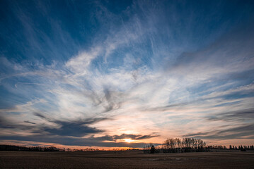 Sunset cloudy sky over the field landscape