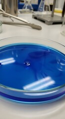Chemical solution displays vibrant blue coloration within a laboratory petri dish