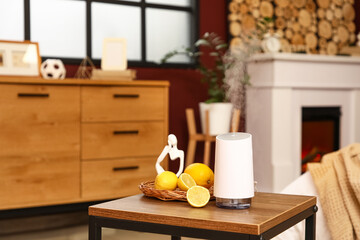 Aroma diffuser with lemons and statuette on table in room