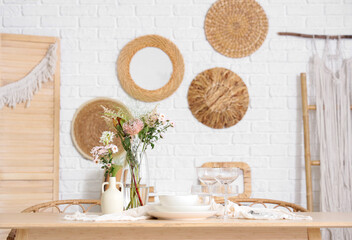 Beautiful table setting with bouquet of flowers in light dining room