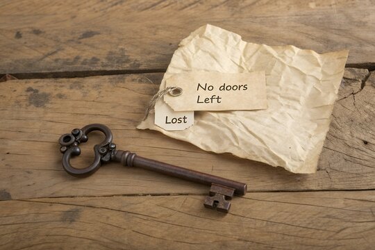 Old antique key lies on wooden surface with lost tags