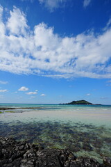 clear shoaling beach and far island