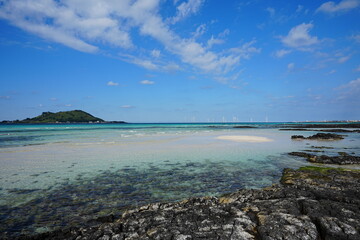 clear shoaling beach and far island