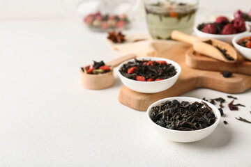 Bowls with dry fruit tea on white grunge table, closeup