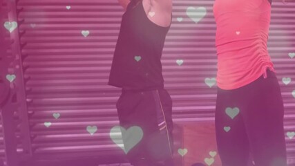 On partner cue, pair performing medicine ball squat press for strength in gym, pink-heart overlay - Powered by Adobe
