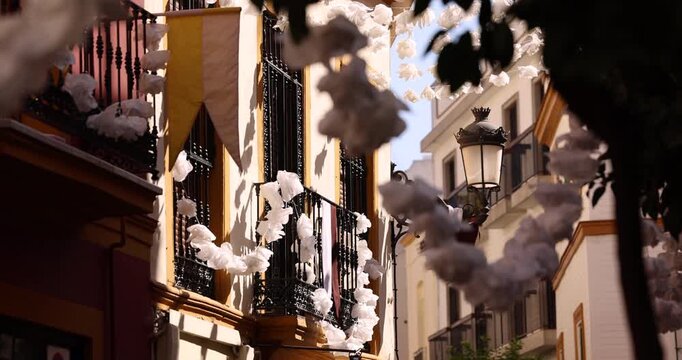 Beautiful white garland hangs across the street in the historic old city of Seville, Andalusia, Spain.