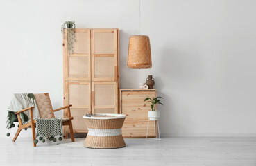 Interior of living room with wooden closet, armchair and table