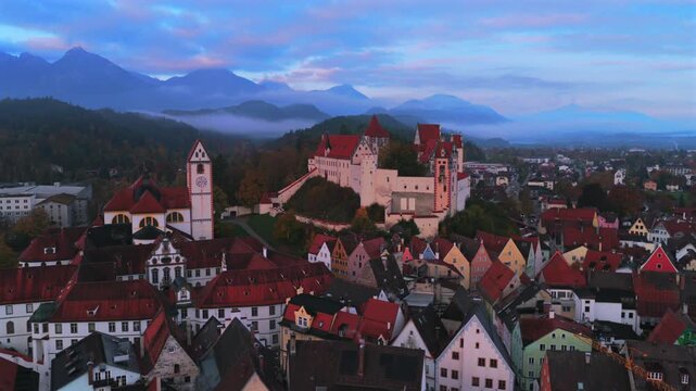 F&uuml;ssen Fussen Bavarian Alps Germany Deutschland aerial drone Bavaria city old town buildings autumn fall morning sunrise sunny blue sky low clouds fog Altstadt Schwaben region parallax circle right