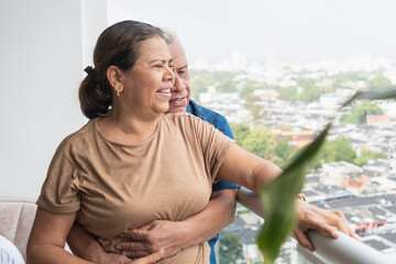 Elderly couple embracing on balcony showing true love