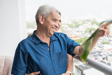 Senior couple sharing true love on balcony pointing at city view