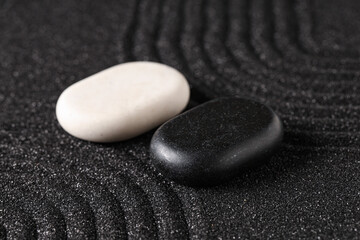 Stones on black sand with lines. Yin Yang concept