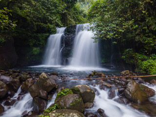 Obraz premium Aerial Long-Exposure Photo of Batur Waterfall in the Jungle – Java Island, Indonesia