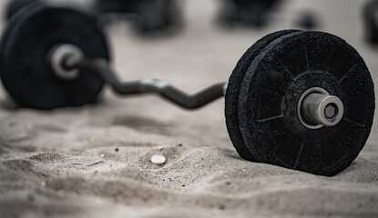 Outdoor gym background. Metal kettlebell on sand. Urban gum in outdoor gym. Natural workout. Gym weights background. Summer training background. Barbell and dumbbell background.