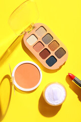 Set of decorative cosmetics on yellow background