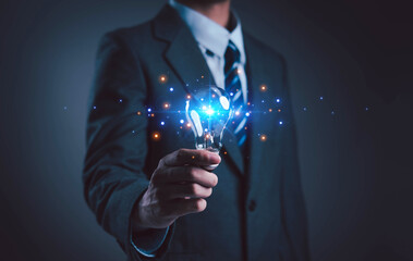 Innovation and inspiration concept. Businessman holding creative light bulb with industry and marketing development network icons. Strategic planning. Modern business and inspiration Idea innovation