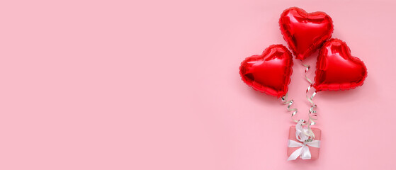 Composition with gift box and heart shaped balloons on pink background. Valentine's Day celebration