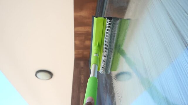 Cleaning windows with a squeegee on a sunny day