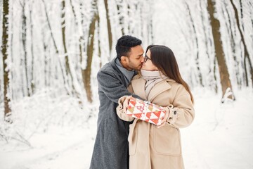 Portrait of a romantic couple spending time together in winter forest