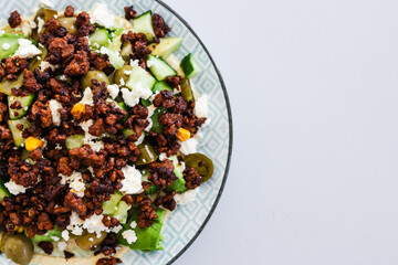 healthy nourish bowl with spicy vegan mince, avocado, olives, cucumber and hummus
