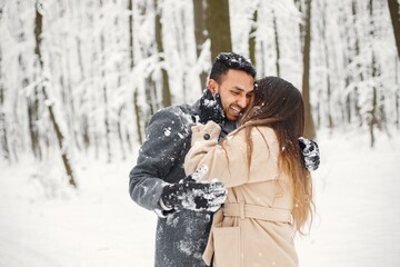Portrait of a romantic couple spending time together in winter forest