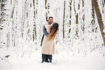 Portrait of a romantic couple spending time together in winter forest